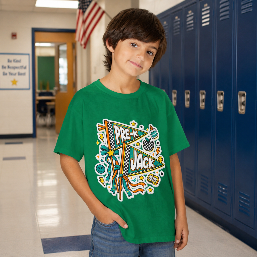 A young boy wearing a green graphic t-shirt with a 'PRE-K JACK' sports design, standing in a school hallway with blue lockers behind him.