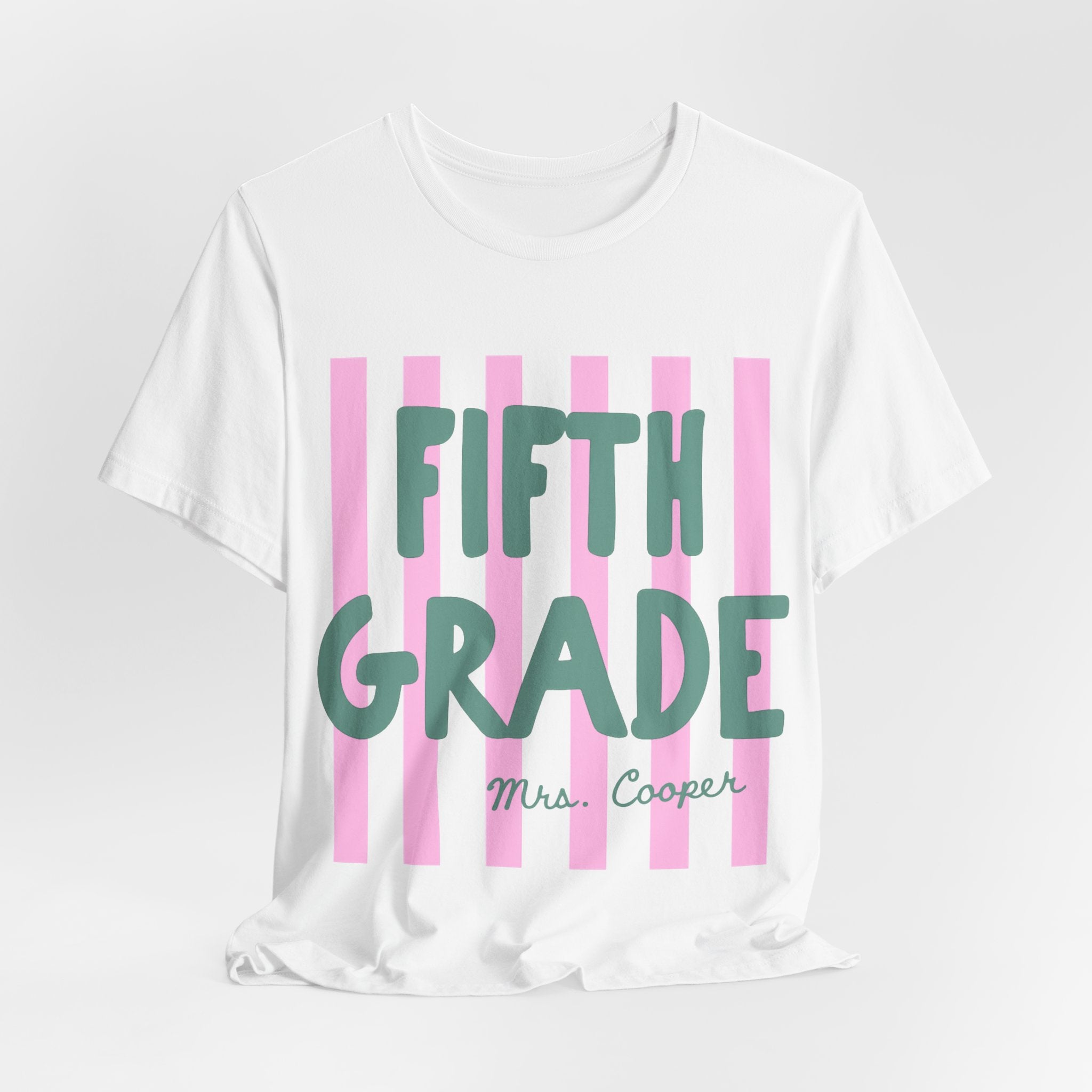 Five personalized striped teacher grade tees in assorted colors, flat lay