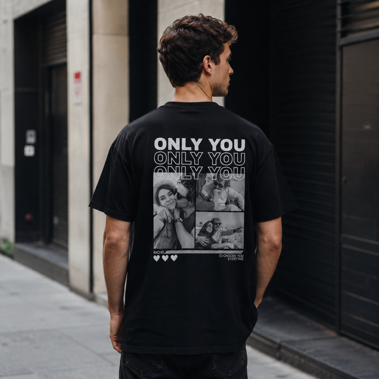 Man wearing a black t-shirt with 'Only You' text and collage on the back, standing on a street.