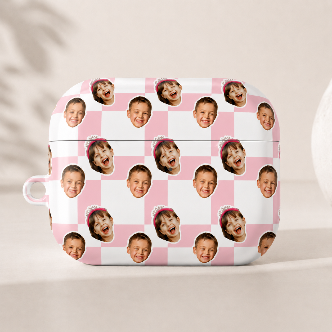 Checkered pink and white case with multiple faces printed on a light background