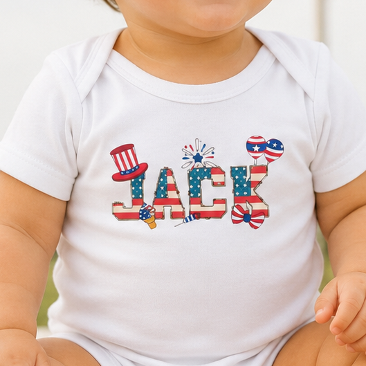 Baby wearing a onesie with 'Jack' printed on it, sitting outdoors with an American flag in the background.
