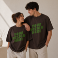 Two people wearing brown t-shirts with 'Your Design Here' text in green.