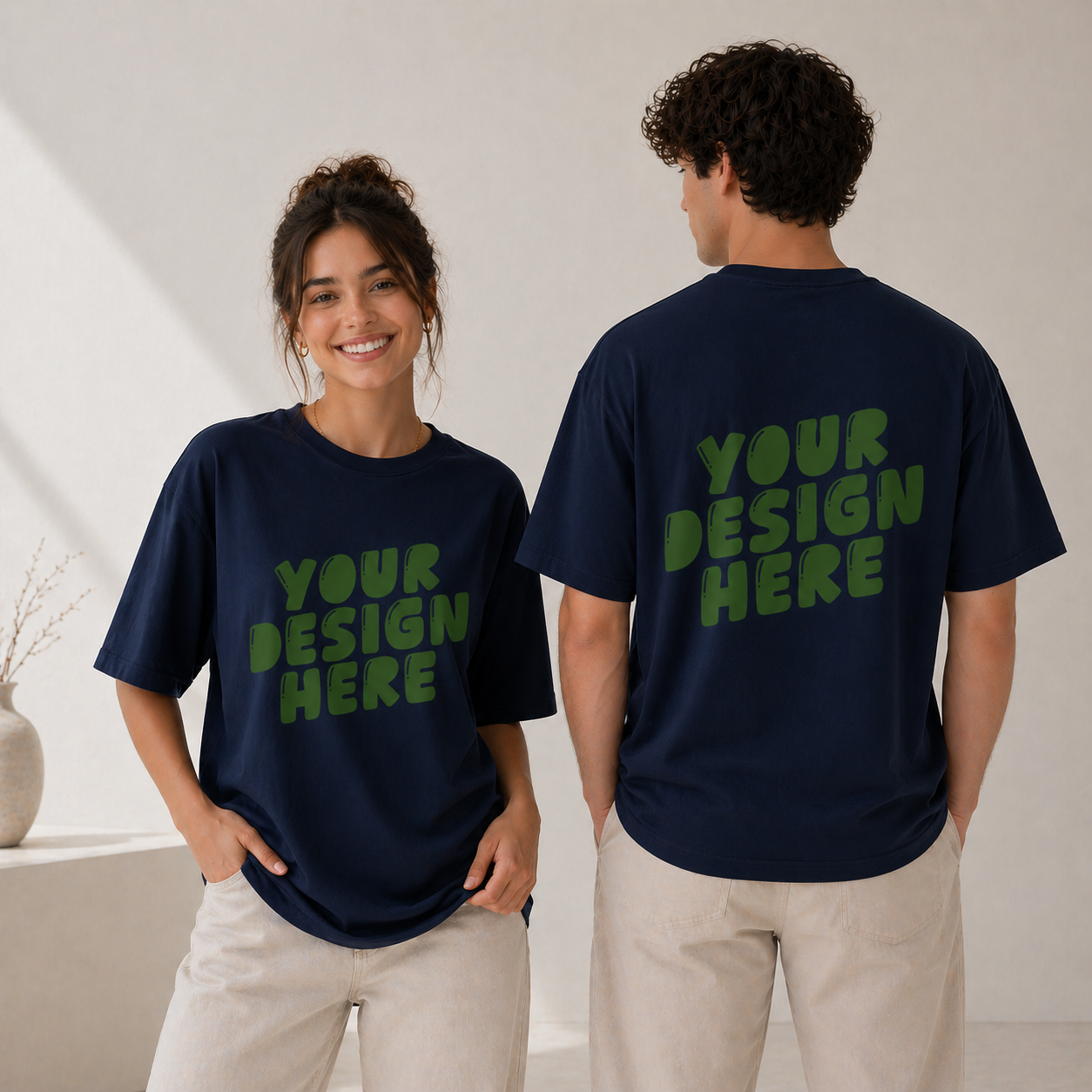 Two people wearing navy blue t-shirts with 'Your Design Here' text in green.