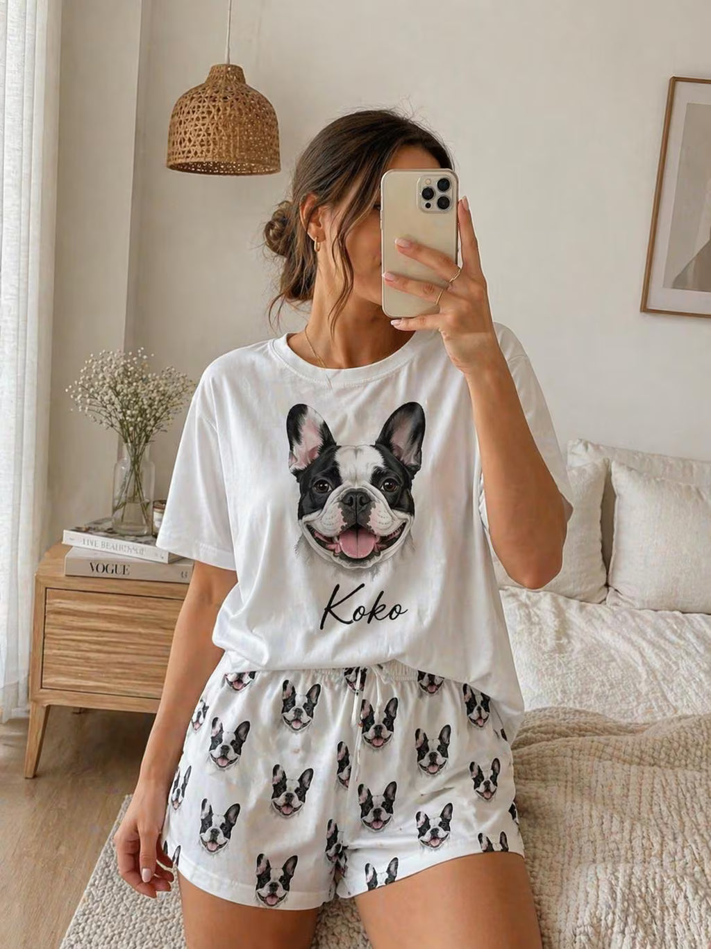 Person wearing a white t-shirt with a dog graphic and shorts in a bedroom.