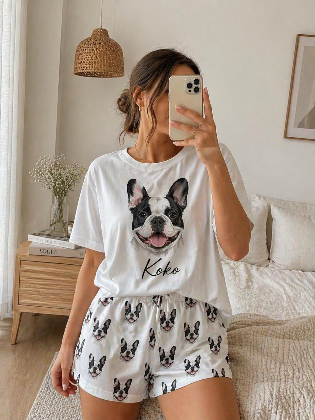 Person wearing a white t-shirt with a dog graphic and shorts in a bedroom.