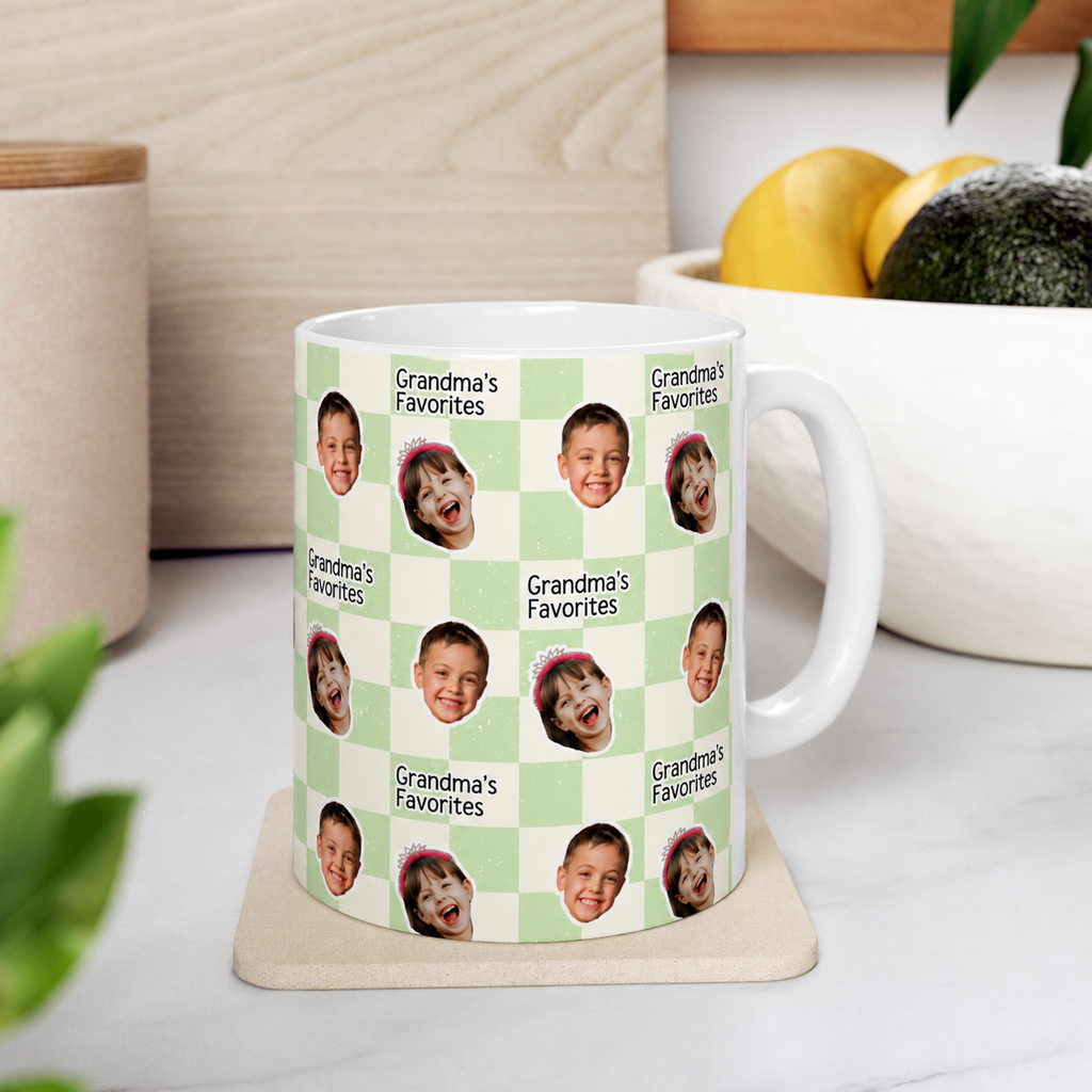 Mug with 'Grandma's Favorites' design featuring children's faces on a checkered background, placed on a coaster.