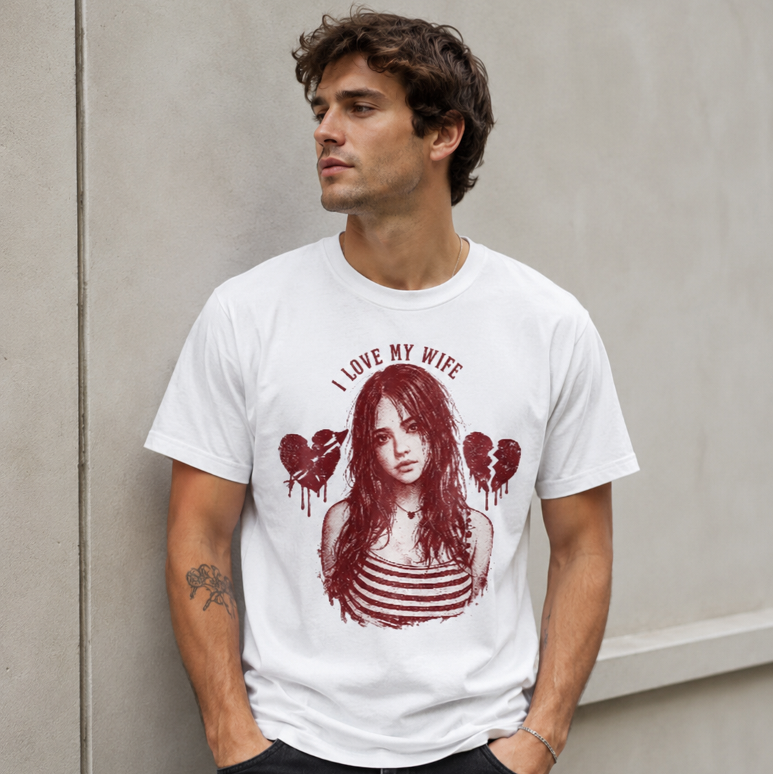 Man wearing a white t-shirt with a graphic design and text, standing against a plain wall.