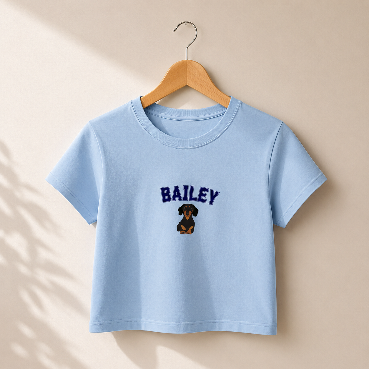 Light blue t-shirt with 'BAILEY' and a dog graphic on a beige background