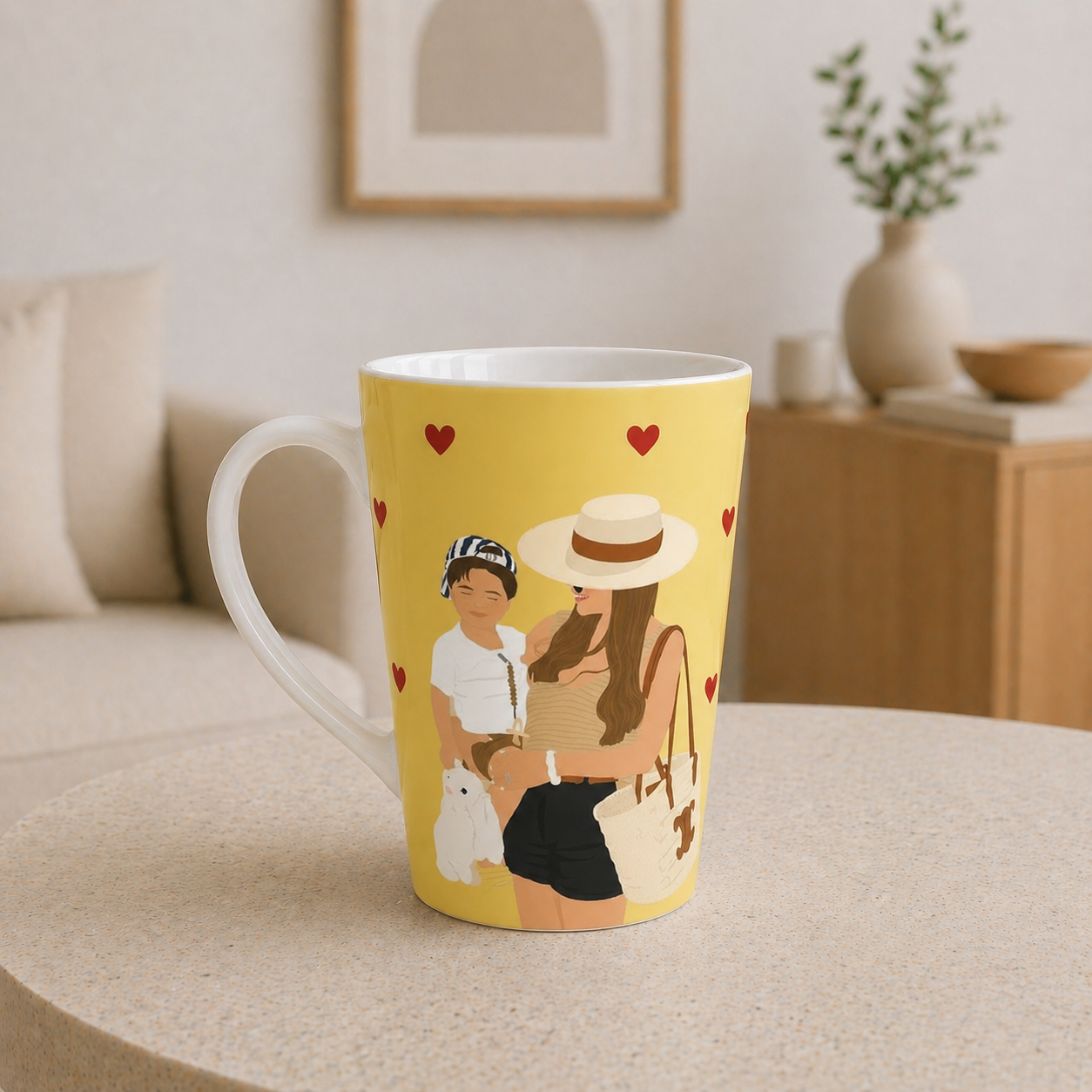 Yellow mug with a design of a woman, child, and dog on a beige surface.