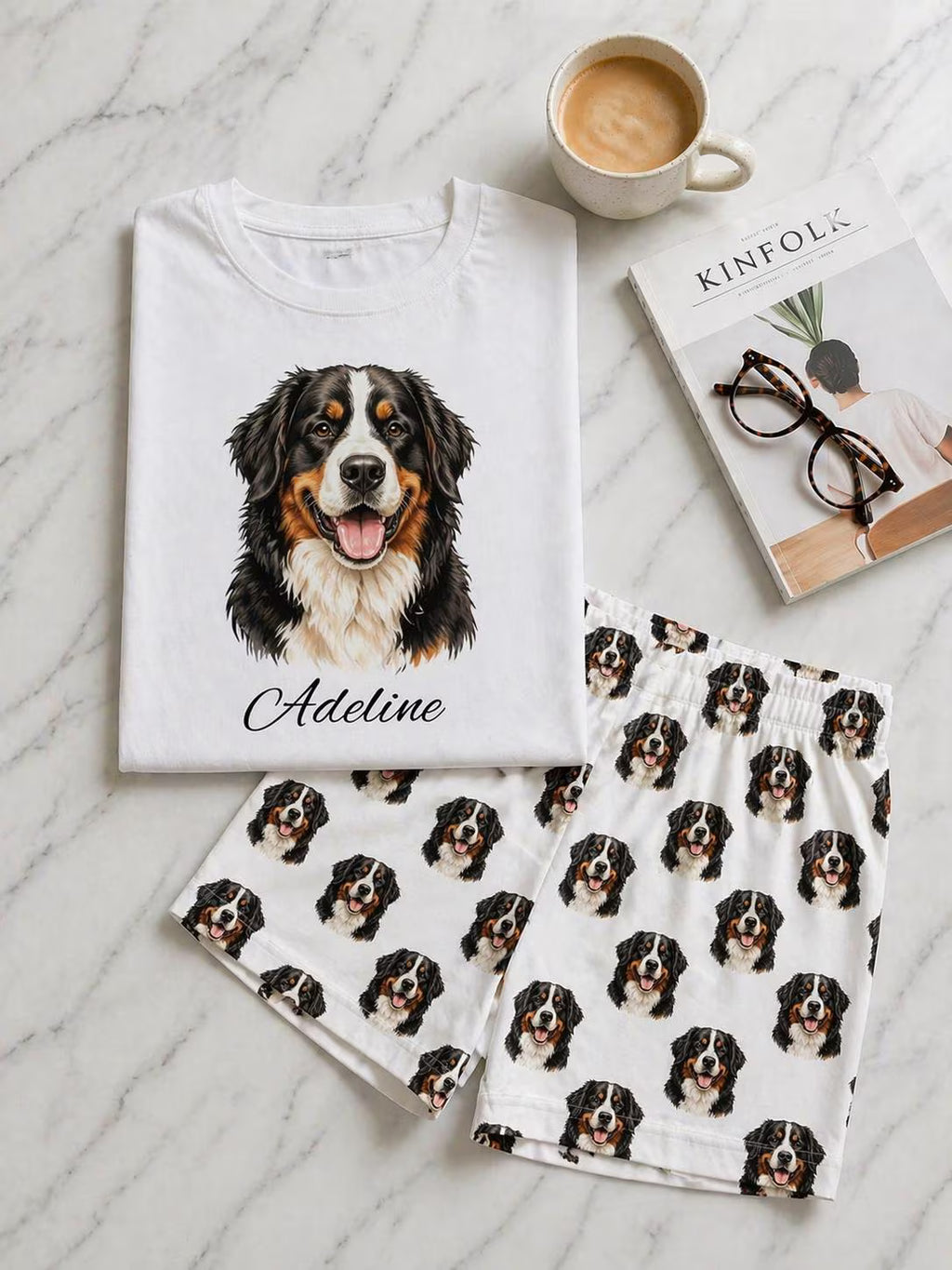 White t-shirt with a dog illustration and name, matching pajama set, and coffee on a marble surface.