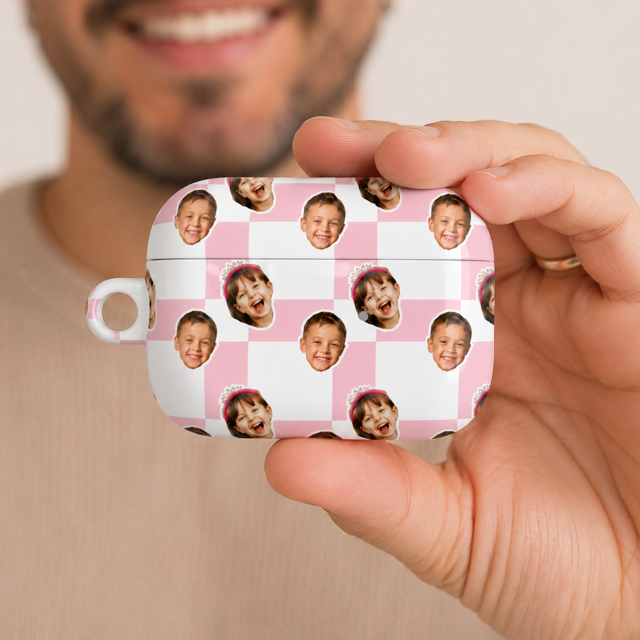 Person holding a pink checkered case with multiple small images of a child's face on it.