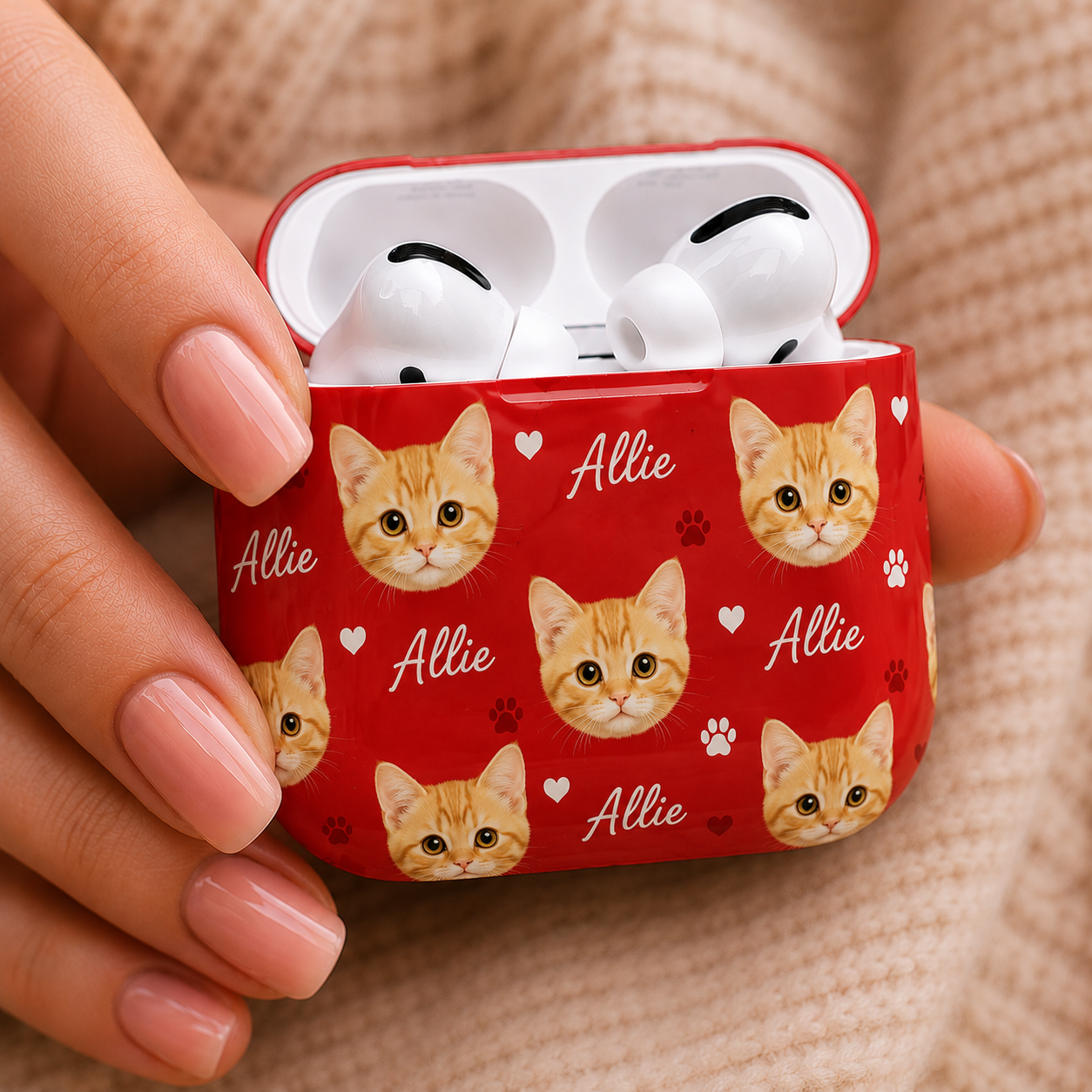 Red AirPods case with cat pattern and 'Allie' text held by a hand.